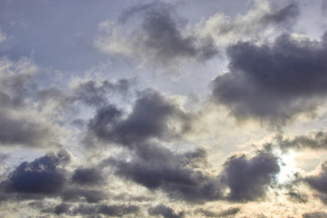 low-floating Cumulus clouds at dawn against a blue sky