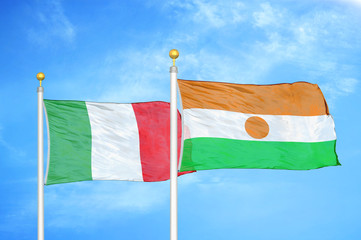 Italy and Niger two flags on flagpoles and blue cloudy sky