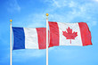 France and Canada  two flags on flagpoles and blue cloudy sky