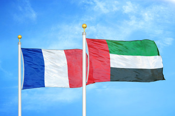 France and United Arab Emirates two flags on flagpoles and blue cloudy sky