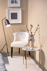 Wall Mural - Part of the bedroom design, white armchair, brass glass table, cotton in vase, floor lamp, wall pictures