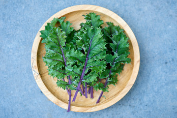 Red Russian Kale on Wooden Plate Overhead View