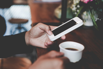 Womanhand using smartphone to do work business, social network, communication in public cafe work space.