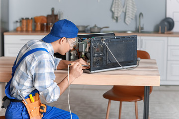 Sticker - Worker repairing microwave oven in kitchen