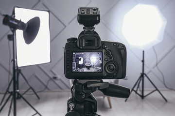 Professional camera on tripod in modern photo studio