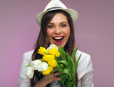 Fototapeta Tulipany - Close up face portrait of happy woman holding flowers.