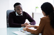 © Andrey Popov - Financial Advisor Discussing Invoice With Her Client