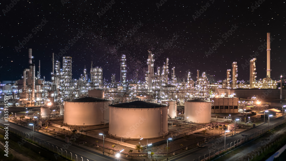 Oil and gas refinery plant and storage tank form industry zone at night ...