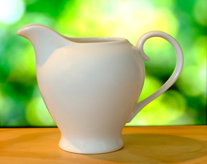 Wall Mural - cup with tea and teapot on bogeh background, over light