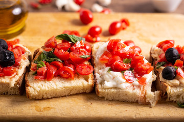 Wall Mural - Mix of bruschette with cherry tomatoes and cream cheese, hummus and black olives. Italian food, healthy appetizer