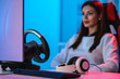 © Artem - The beautiful gamer girl with headphones playing video games