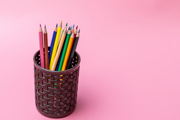 Wall Mural - Various color pencils in brown office cup on pink background.