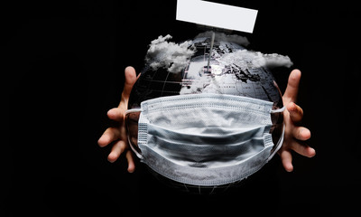 Wall Mural - on black background child hands holding globe covered with medical protective mask our planet under 