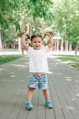 little smiling girl model in white shirt phaving fun in park