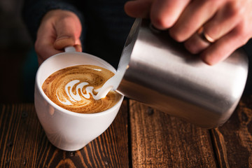 Wall Mural - Barista pouring milk into cappuccino cup