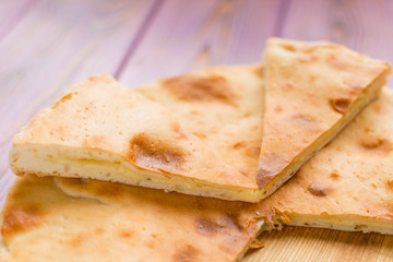 Wall Mural - Pie with cheese on a wooden pink background. Khachapuri - flat cake with cheese.