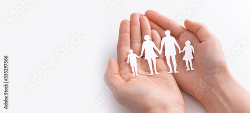 Fotografía Family care concept. Hands with paper silhouette on table.