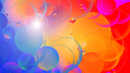 bright oily drops in water with colorful background, close-up