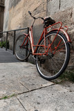 Fototapeta Uliczki - Old vintage orange bicycle urban   