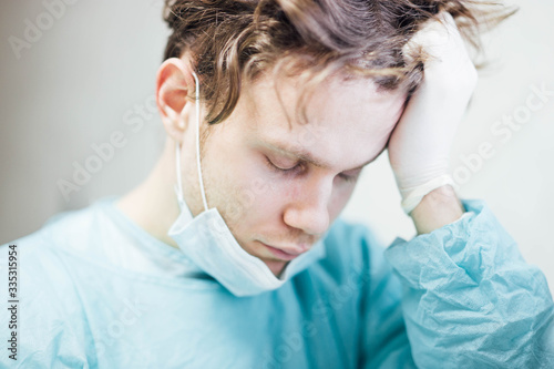 Fotomural tired and sad doctor surgeon in depression is upset and holds his head