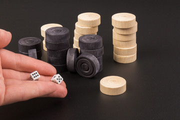 Backgammon. Board game. White cubes and chips on a blackboard.  Dice on backgammon board game. Selective focus. Playing leisure games