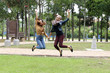 © oqba - Young Asian Malay man woman outdoor green park joy happy jump in the air