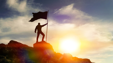 man with flag on top of the mountain against the sky. concept business ideas, success and achievemen