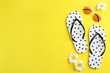 Flat lay composition with flip flops on yellow background. Space for text