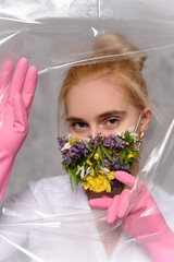 Wall Mural - Quarantined woman wears a protective mask of flowers.
Quarantined woman breakthrough of oilcloth.