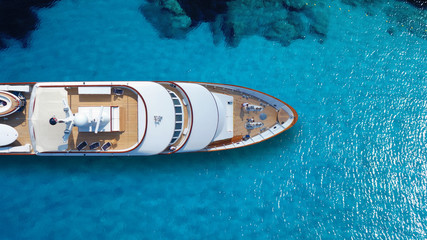 Wall Mural - Aerial drone top down photo of luxury exotic yacht nose with wooden deck anchored in paradise turquoise bay
