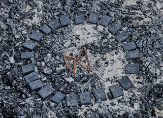 Norse rune Dagaz on ashes backgorund inside the circle of 24 Norse runes