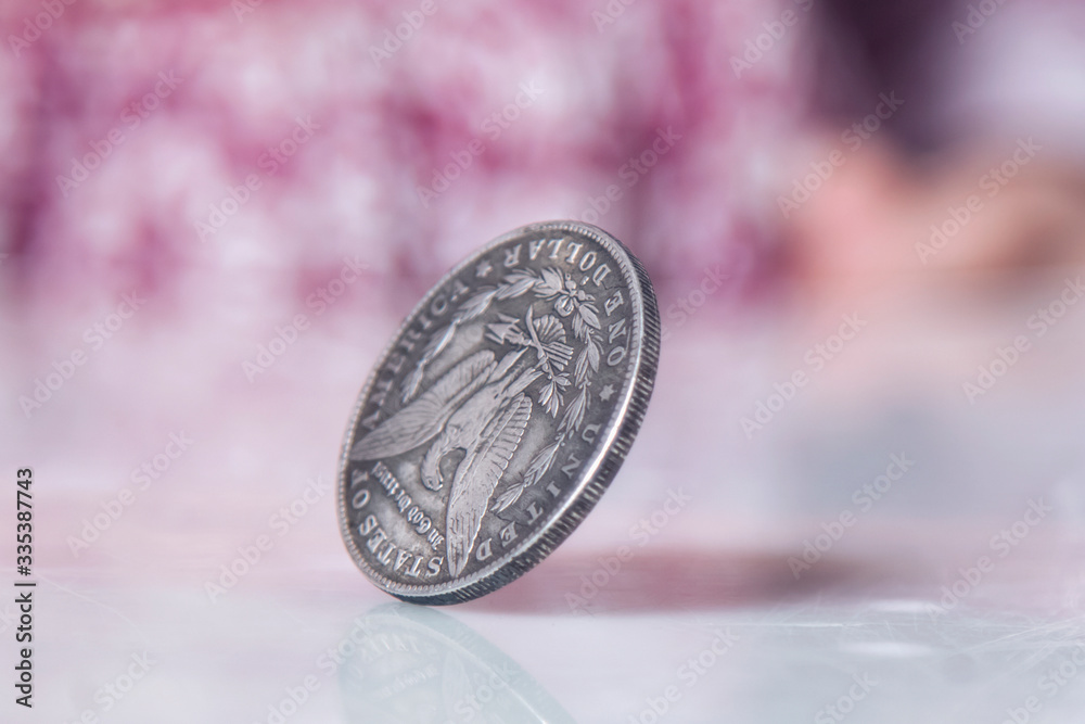 Close up cute little child girl spinning a coin to make decision. Heads or tails game.