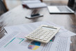 © LIGHTFIELD STUDIOS - Calculator with papers on table in office