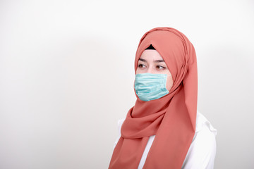 Wall Mural - Muslim girl wearing surgical mask for protection. Hijab woman take a mask for coronavirus or COVID-19 epidemic or pandemic