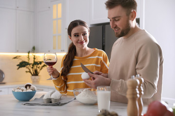 Poster - Lovely young couple cooking dough together in kitchen