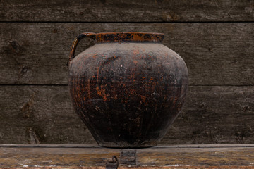 Wall Mural - Photo of an empty clay vase on aged rustic wooden table, retro wooden wall