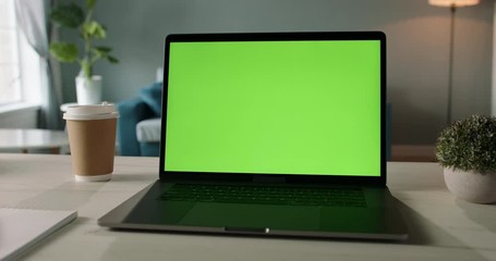 Modern laptop with mock up chroma key green screen st on desk of living room. The only template you need - remote work concept close up 4k video