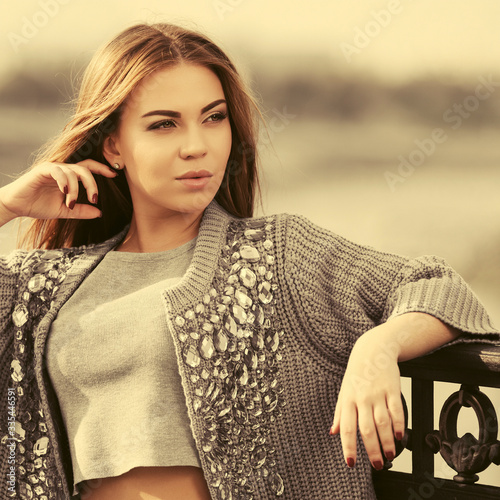Cuadros en Lienzo Happy young fashion woman in grey cardigan leaning on railing