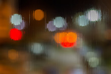 An Abstract Background Of Red And Brown Lights Bokeh Trough Wet Glass At Night Close-up With Selective Focus
