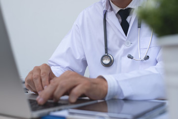 Wall Mural - Doctor working on laptop computer in medical office