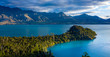 Green lush Forest peninsula on Lake Wakatipo with Southern Alps mountains in the background, aerial view at sunset