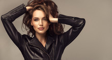 Beautiful Stylish Woman Wearing  Black Leather Jacket. Fashionable And Self-confident Girl With Long Curly Hair. Clothing, Style And Fashion