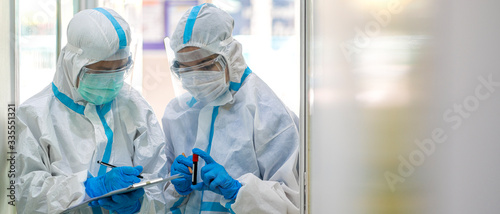 Banner photo of Asian doctor show corona or covid-19 blooding tube wearing ppe suit and face mask in hospital Poster Mural XXL
