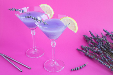 Wall Mural - Lavender drink  with lemon in martini glasses  on the bright pink  background. Location vertical.