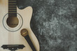 © osabee - Table top view of music instrument tools concept background.Flat lay of sign to sing for musician or party equipment.Guitar with microphone on modern grey cement.copy space for creative design.