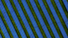 Aerial Drone Photo Of A Photovoltaic Solar Cell Farm. Dark Blue Solar Panels Against A Contrasting Green Grass Field.
