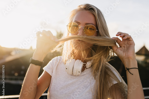 Photographie Inspired european woman playing with her blonde hair in sunny day