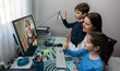 © David Pereiras - Mother and children waving on video call with computer with grandmother