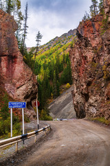 Wall Mural - Altai Republic, Russia - September, 18, 2019: Red Gate Rock, a tourist and natural attraction. The inscription on the road sign: Chibitka River