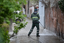 Public Janitor Deep Cleaning The Sidewalk With High Pressure Disinfectant Solution In Times Of Corona Virus Pandemic In A Lockdown Bucharest, Romania